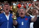 England fans show a replica world cup trophy in the crowd ahead of the international friendly football match between England and Switzerland at Wembley stadium in north London on March 26, 2022. (Photo by Adrian DENNIS / AFP)