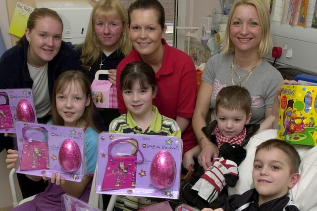 Emma Wood, left, and Jane Mather, from Marks and Spencer, Stadishgate, hand out Easter eggs to children on Wigan Infirmary's Rainbow Ward.  Rebecca Clark, 10, Emma McHugh, 10, and Nathan Bevan, eight, along with brother Ronan and mum Tina are pictured with play specialist Tracey Parfitt