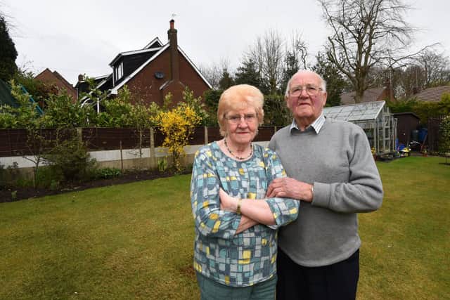Bernie and Tom Griffin, in their garden, with the neighbouring property which is subject to planning permission.