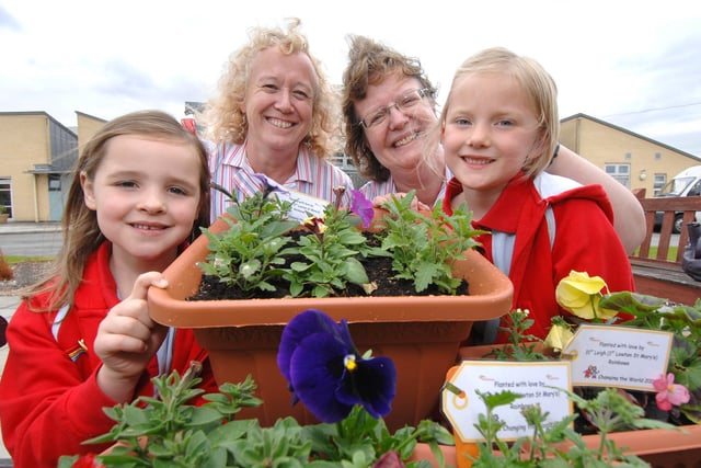 Members of the 31st Leigh (1st Lowton St Mary's) Rainbows with flower troughs and pots made for Wigan and Leigh Hospice in 2009