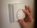 Undated file photo of a person using a central heating thermostat.