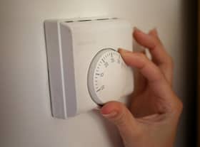 Undated file photo of a person using a central heating thermostat.