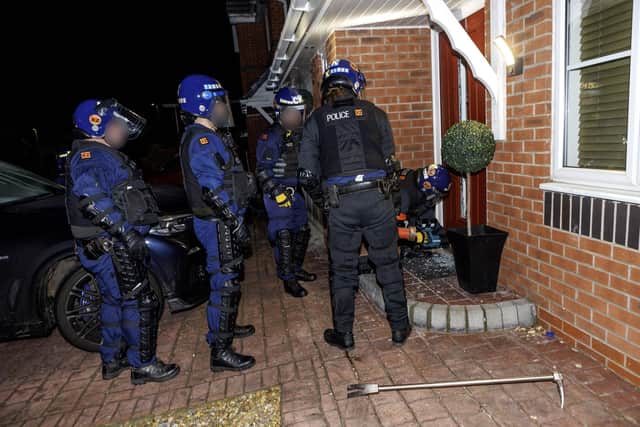 Police force their way into a house in Wigan during the early-morning raids