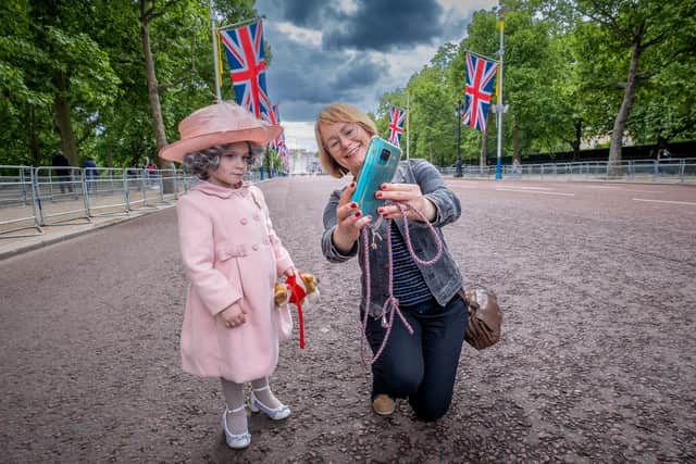Isla Bates dressed up as mini-queen meets tourists on the Mall outside Buckinham Palace