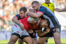 Tonga's Siliva Havili is tackled by England's Elliott Whitehead and Harry Smith