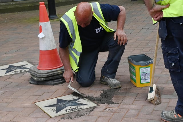 Wigan Council workers place the star on the Walk of Fame outside Leigh Town Hall.
