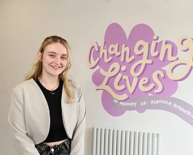 Amy Madden, founder of All Ears, next to a mural in memory of Aleysha Rothwell