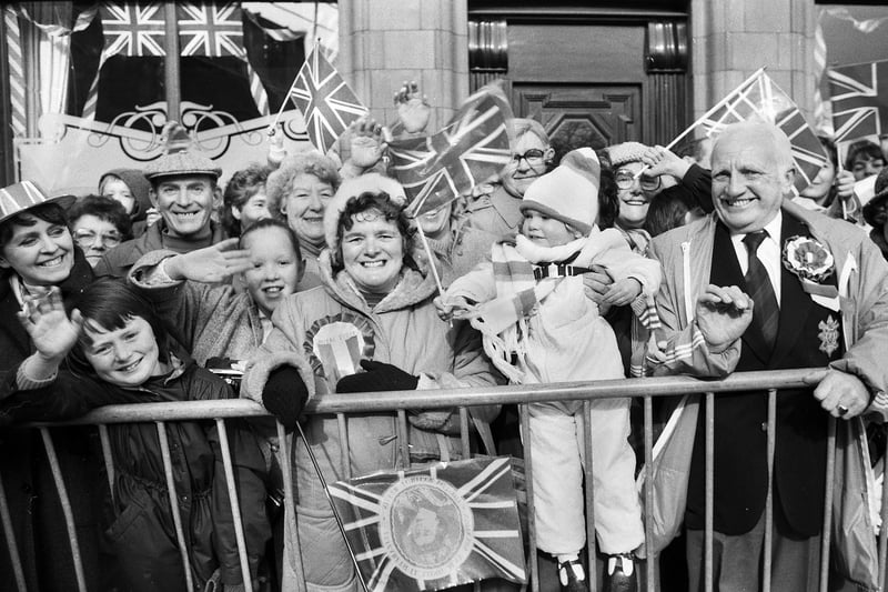 Swan and Royalty. A warm Wigan welcome from smiling townsfolk outside the Union Jack flying Swan and Railway Hotel in Wallgate and, centre, three year old Sarah Watson, of Coppull with a first class view.