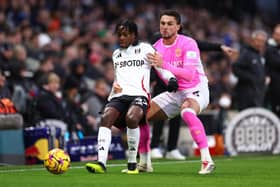 Martial Godo holds off a challenge from Taylor Harwood-Bellis of Southampton during his Premier League debut for Fulham