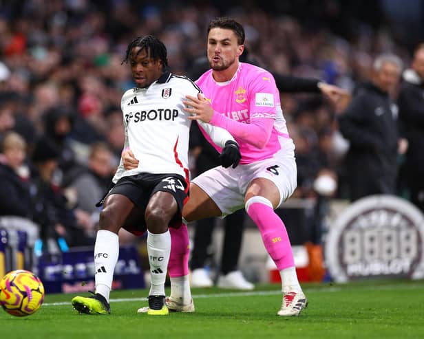 Martial Godo holds off a challenge from Taylor Harwood-Bellis of Southampton during his Premier League debut for Fulham
