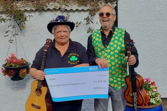 Organisers Maggie and Gary holding the cheque for the money raised by the Ukraineulele