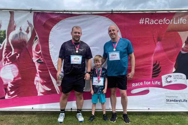 Rory Whyte flanked at the Race for Life finish line by his dad Nicky (right) and uncle James