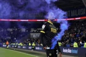 Miguel Azeez picks up a flare at Cardiff, which earned him a one-match ban from the FA