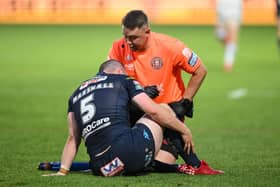Liam Marshall receives treatment from medical staff in Wigan Warriors' defeat to Wakefield Trinity in Round 15