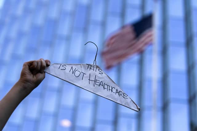 A woman holds up a coat hanger symbolizing unsafe, illegal abortions during a protest outside a federal courthouse in Los Angeles (AP Photo/Jae C. Hong)