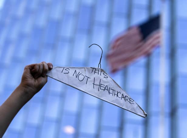 A woman holds up a coat hanger symbolizing unsafe, illegal abortions during a protest outside a federal courthouse in Los Angeles (AP Photo/Jae C. Hong)