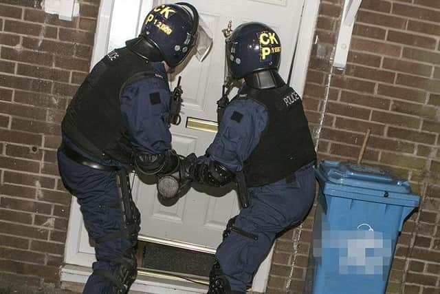 Police break down a door
