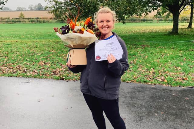 Diane with flowers and a certificate to prove she completed her scary challenge