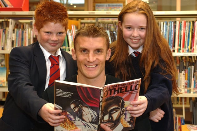 Wigan Athletic player Matt Jackson visited Standish High School to promote  Own Book Week. Pictured helping Matt brush up on his Shakespeare are Robbie Lannon, and Pearl Goldsbrough.