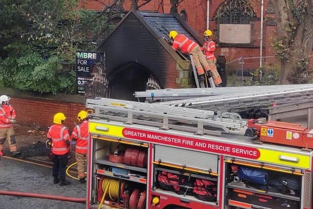 Firefighter remove slates from the lychgate roof at the former St Thomas's church to ensure all the flames were out