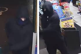 The masked and hooded robber during the Premier shop raid