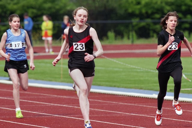 Wigan Harriers' Louise Edgar, (centre), strides home to win her heat of the Under 15s girls 100 metres in the first Mid-Lancs League meeting of the season at the Robin Park Arena on Saturday 17th of April 1999.