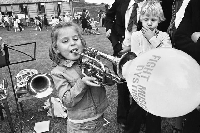 A young girl blows up a charity balloon at St. Williams Gala, Higher Ince, in September 1975.