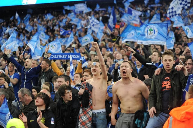 Latics fans celebrate the Wigan win after the final whistle