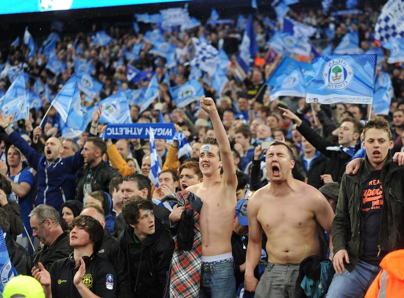 Latics fans celebrate the Wigan win after the final whistle