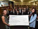 Headteacher Alison Rigby, left, with staff and pupils, presents the cheque to Emily Durkin-Kenyon and Maureen Holcroft, from Daffodils Dreams