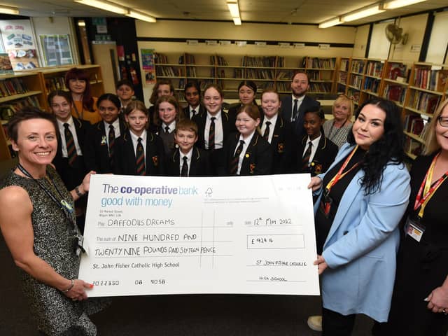 Headteacher Alison Rigby, left, with staff and pupils, presents the cheque to Emily Durkin-Kenyon and Maureen Holcroft, from Daffodils Dreams