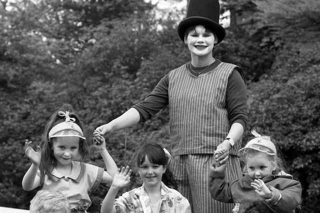 Cousins Terri Kelly, Jemma Jones and Jody Kelly reach the heights with a stilt walker at the May Day Carnival at Haigh Hall on Monday 4th of May 1987.