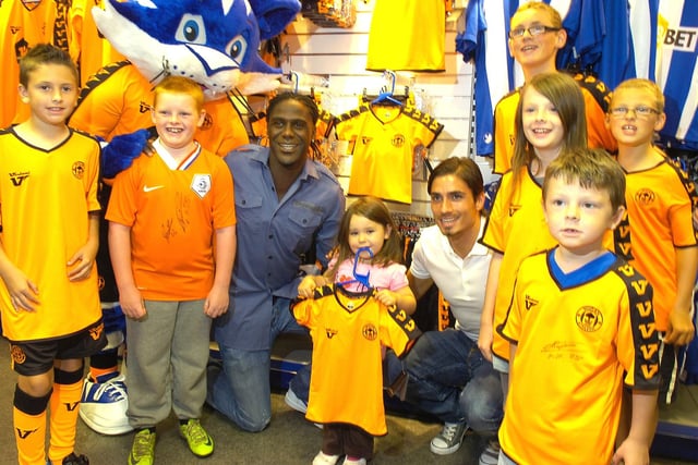 All smiles at the Wigan Athletic away shirt launch at the club shop with Mario Melchiot and Daniel De Ridder with little Kimberley Bolton (4) and young fans at the launch.