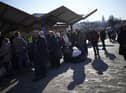 People wait in a line to board a train leaving for Lviv in Ukraine at the train station in Przemysl, Poland, Monday, March 14, 2022. While tens of thousands of people have fled Ukraine every day since Russia's invasion, a small but growing number are heading in the other direction. At first they were foreign volunteers, Ukrainian expatriate men heading to fight and people delivering aid. But increasingly, women are also heading back.