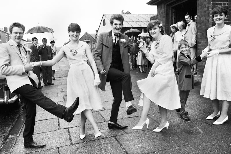Rock and Roll fans Paul Mayston and Deborah Guthran flanked by best man, bridesmaids and page boy after rocking down the aisle for their wedding at Sacred Heart RC Church, Springfield, on Saturday 11th of June 1983.