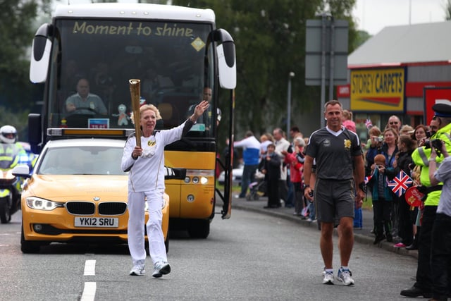 Torchbearer 099  carries the Olympic Flame on the Torch Relay leg between Wigan and Ince-in-Makerfield.