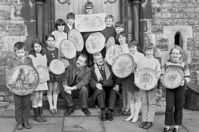 Pupils at St. Thomas's Junior School, Caroline Street, Wigan, in January 1971 learning about the new currency just prior to decimalisation with help from headmaster, Douglas Hedley, left, and former teacher Tom Ashcroft.
