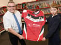 from left, Coun Chris Ready presents the signed rugby shirt to Year Five pupil Wilson, accepting it for the school.