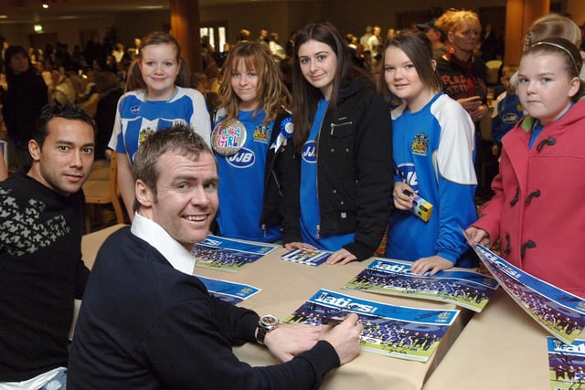 JJ'S WORLD CHRISTMAS PARTY - Wigan Athletic's Denny Landzaat and Stephen McMillan sign team posters for young fans at JJ's World Christmas Party.