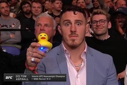 Tom Aspinall holds up a duck to underline his belief Jon Jones has been ducking a unification fight