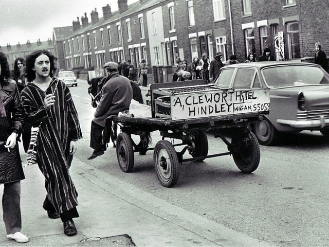 Hippies trudge through Bickershaw village on their way to the music festival as Hindley rag and bone man A. Cleworth does his rounds in 1972.