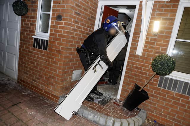Doors were cut down by police as they raided homes in Wigan and Bolton