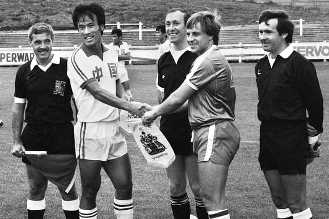 China's captain, Lin Luofeng, and Latic's captain, Eamonn O'Keefe, exchange pennants before the friendly match at Springfield Park on Saturday 14th of August 1982. The match was a 1-1 draw.