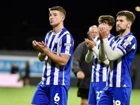 Callum Lang applauds the travelling Latics fans with Charlie Hughes
