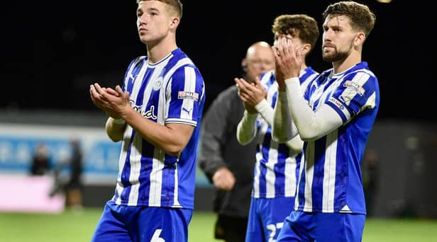 Callum Lang applauds the travelling Latics fans with Charlie Hughes