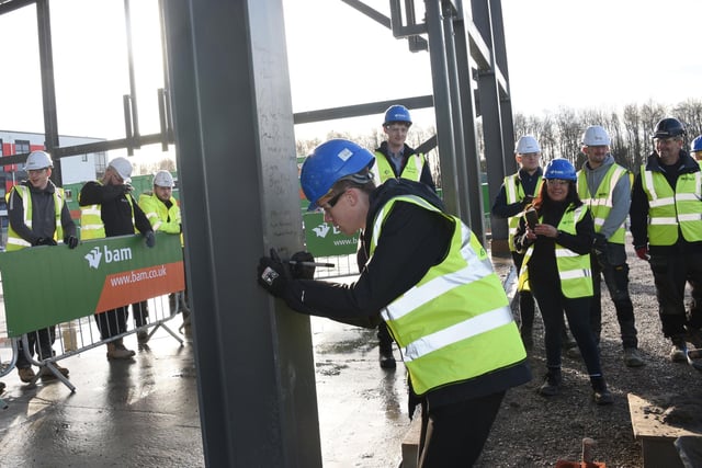 Head Boy Alfie Dunkerley signs the steel framework of the new school building.