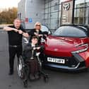 Jack Johnson, 16, does the Joining Jack "salute" with HW Moon Toyota's sales manager Paul Hughes and managing director Dorothy Moon as he collects the lead car for Run Wigan Festival