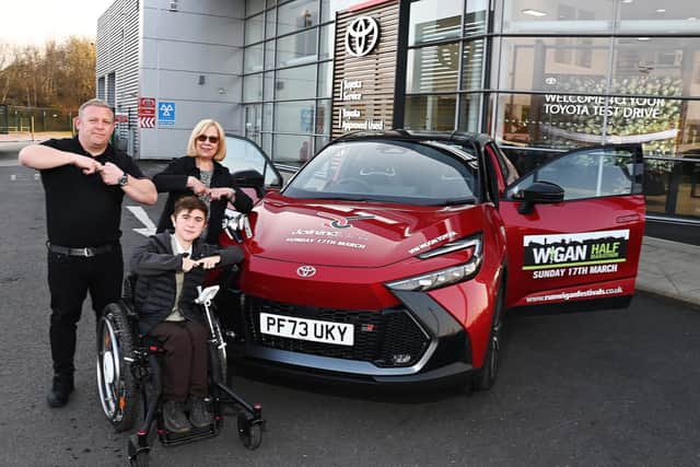 Jack Johnson, 16, does the Joining Jack "salute" with HW Moon Toyota's sales manager Paul Hughes and managing director Dorothy Moon as he collects the lead car for Run Wigan Festival