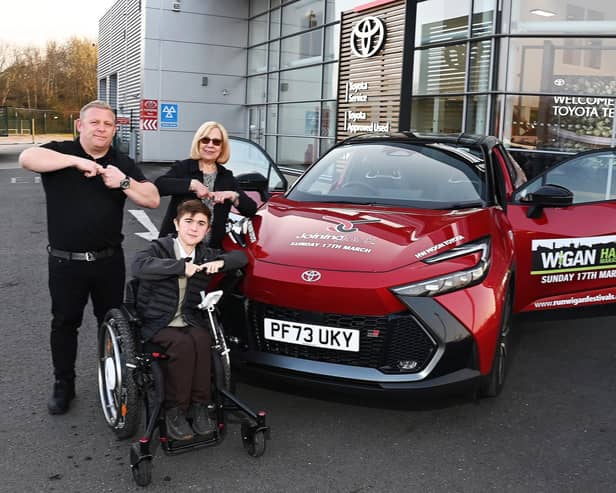 Jack Johnson, 16, does the Joining Jack "salute" with HW Moon Toyota's sales manager Paul Hughes and managing director Dorothy Moon as he collects the lead car for Run Wigan Festival