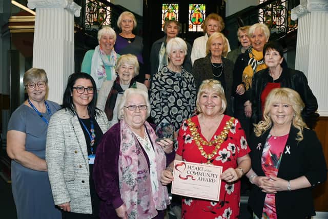 Pauline Carr, front centre, is presented with the Heart of the Community Award by Mayor of Wigan Coun Marie Morgan and Coun Pat Draper, pictured with fellow volunteers, friends and family members at the presentation ceremony at Wigan Town Hall